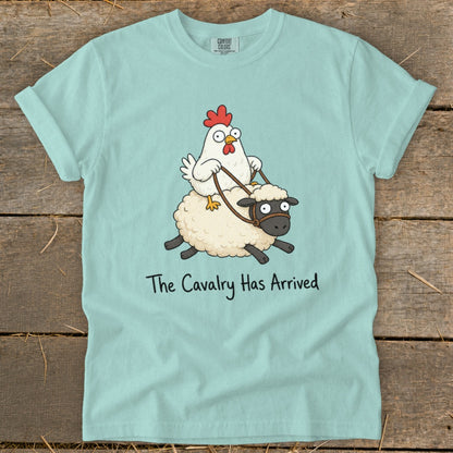 Cartoon chicken riding a sheep with text "The Cavalry Has Arrived" on blue t-shirt.