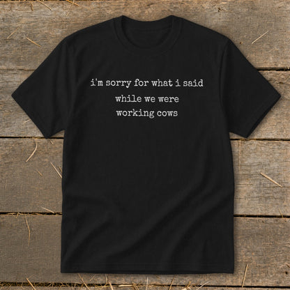 Black t-shirt with white text: "i'm sorry for what i said while we were working cows."
