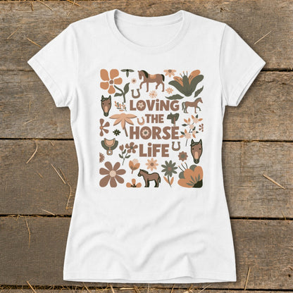 White t-shirt with "Loving the Horse Life" text surrounded by horses, flowers, and equestrian elements.