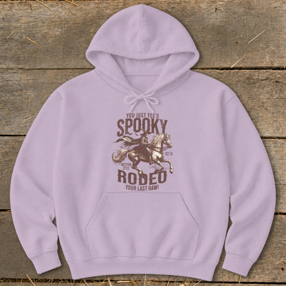 Lilac hoodie with "Spooky Rodeo" graphic featuring a cowboy on a horse.