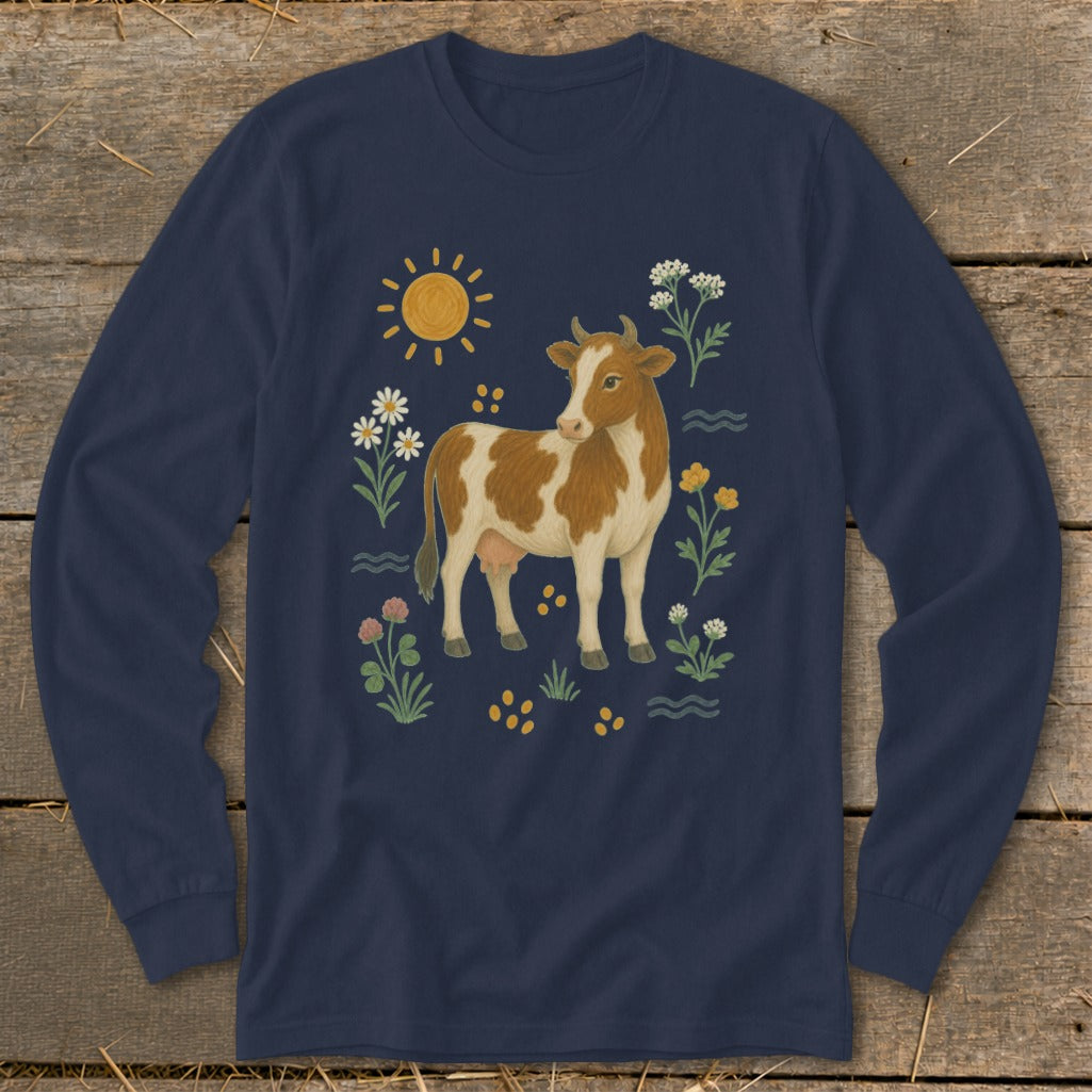 Brown and white cow surrounded by flowers, sun, and yellow dots on a navy shirt.