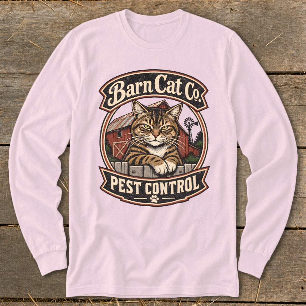 A light pink long-sleeve t-shirt features a vintage graphic centered on the chest, displaying a tabby cat behind a fence with a barn and the text Barn Cat Co. Pest Control.