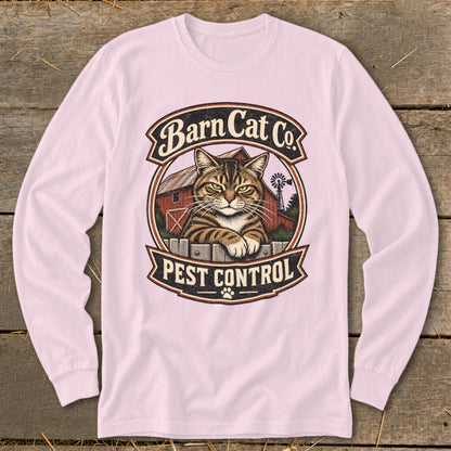 A light pink long-sleeve t-shirt features a vintage graphic centered on the chest, displaying a tabby cat behind a fence with a barn and the text Barn Cat Co. Pest Control.