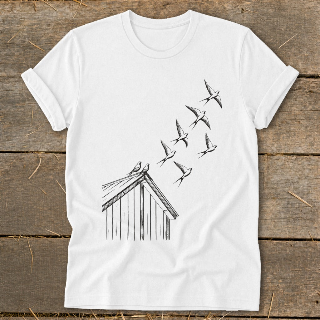 A white t-shirt featuring a black line drawing of swallows flying from a rooftop.