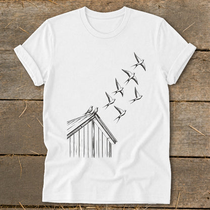 A white t-shirt featuring a black line drawing of swallows flying from a rooftop.