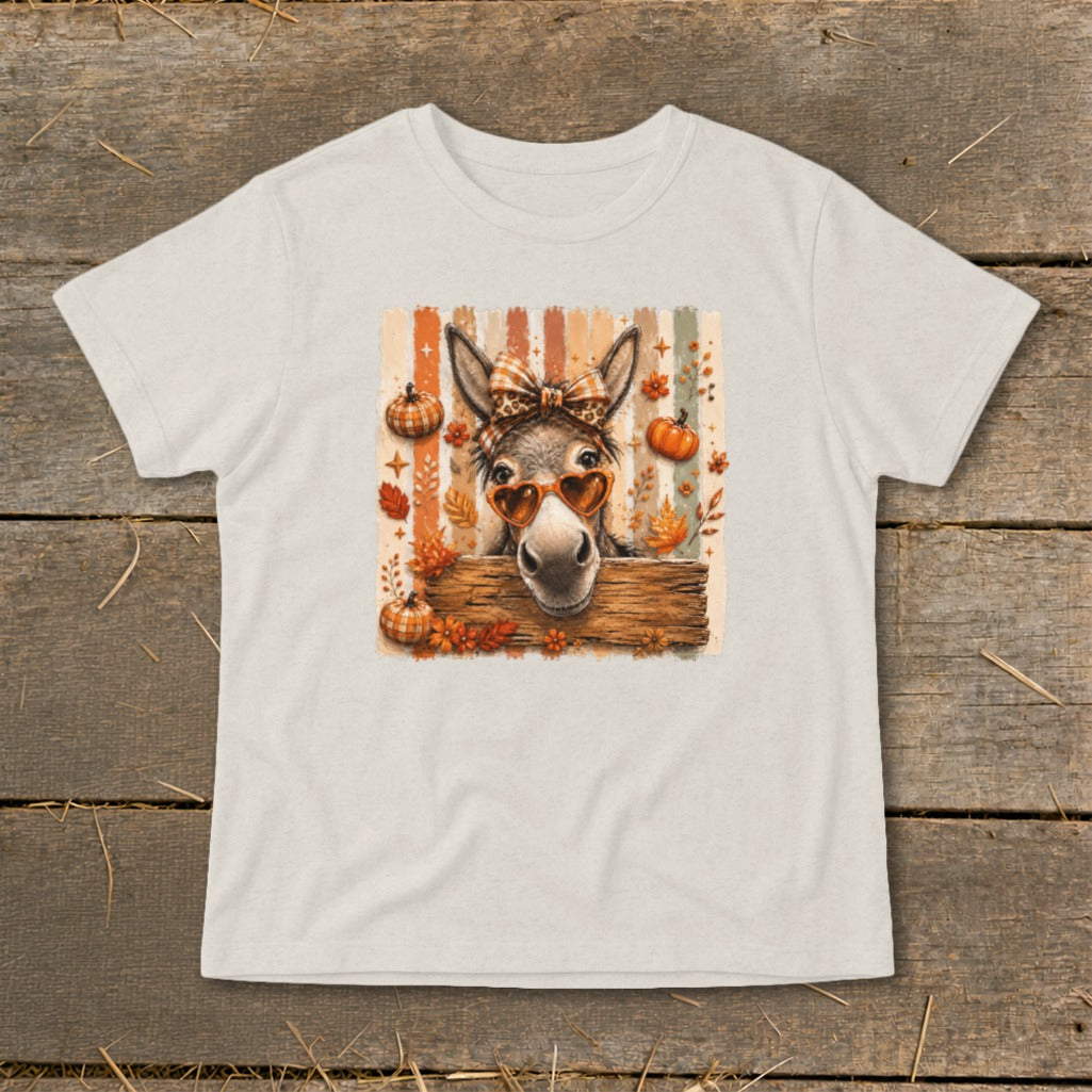 Donkey with heart sunglasses, plaid bow, and pumpkins on striped background.