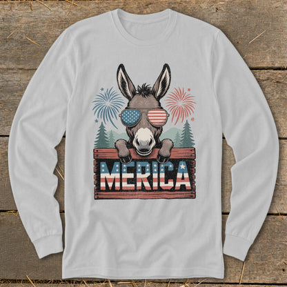 Donkey wearing American flag sunglasses behind "MERICA" sign with fireworks and trees.