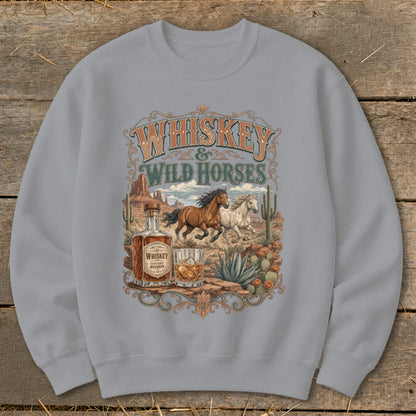 Whiskey & Wild Horses graphic on a gray sweatshirt with desert landscape.