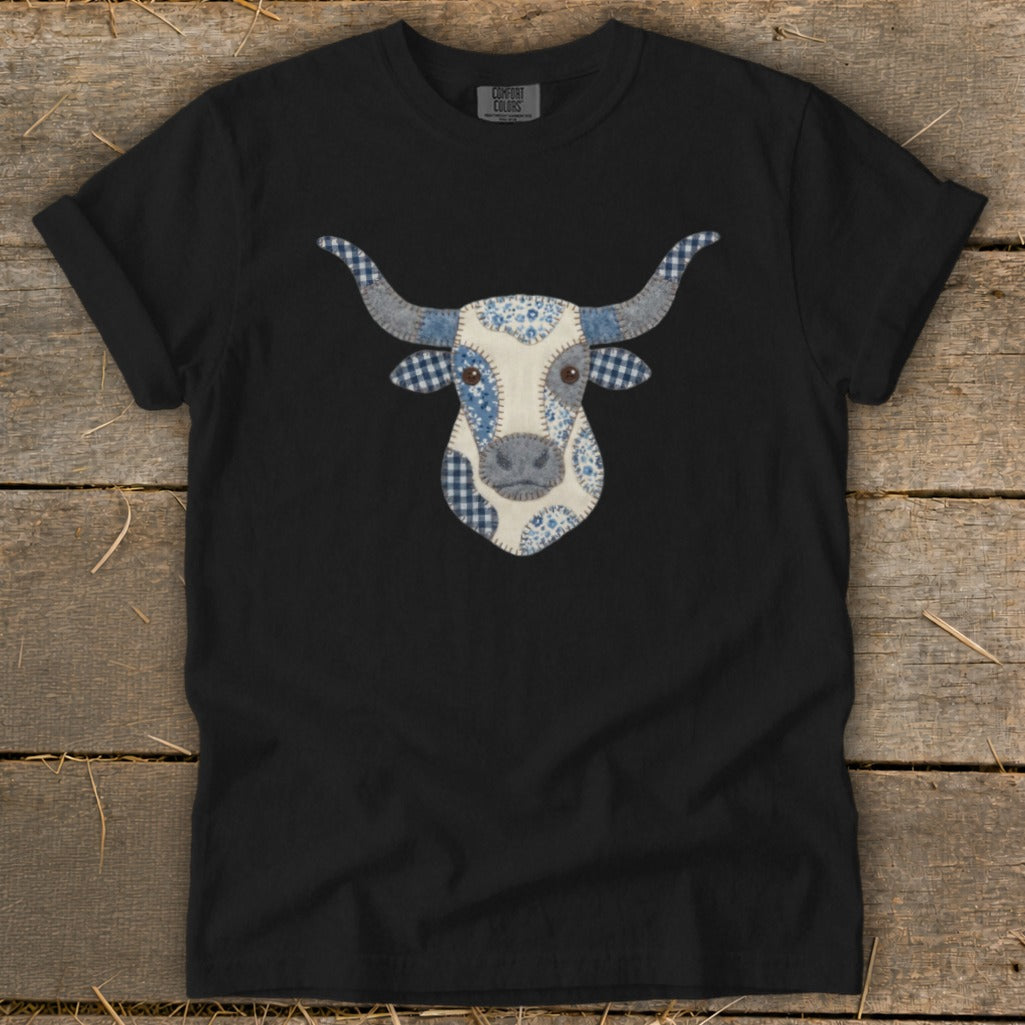 Black t-shirt with a patchwork bull's head graphic in blue and white patterns.