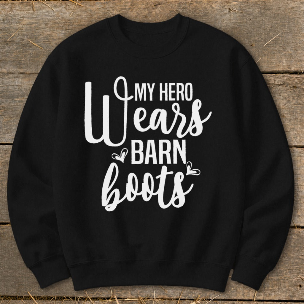 Black sweatshirt with white text reading "My hero wears barn boots"
