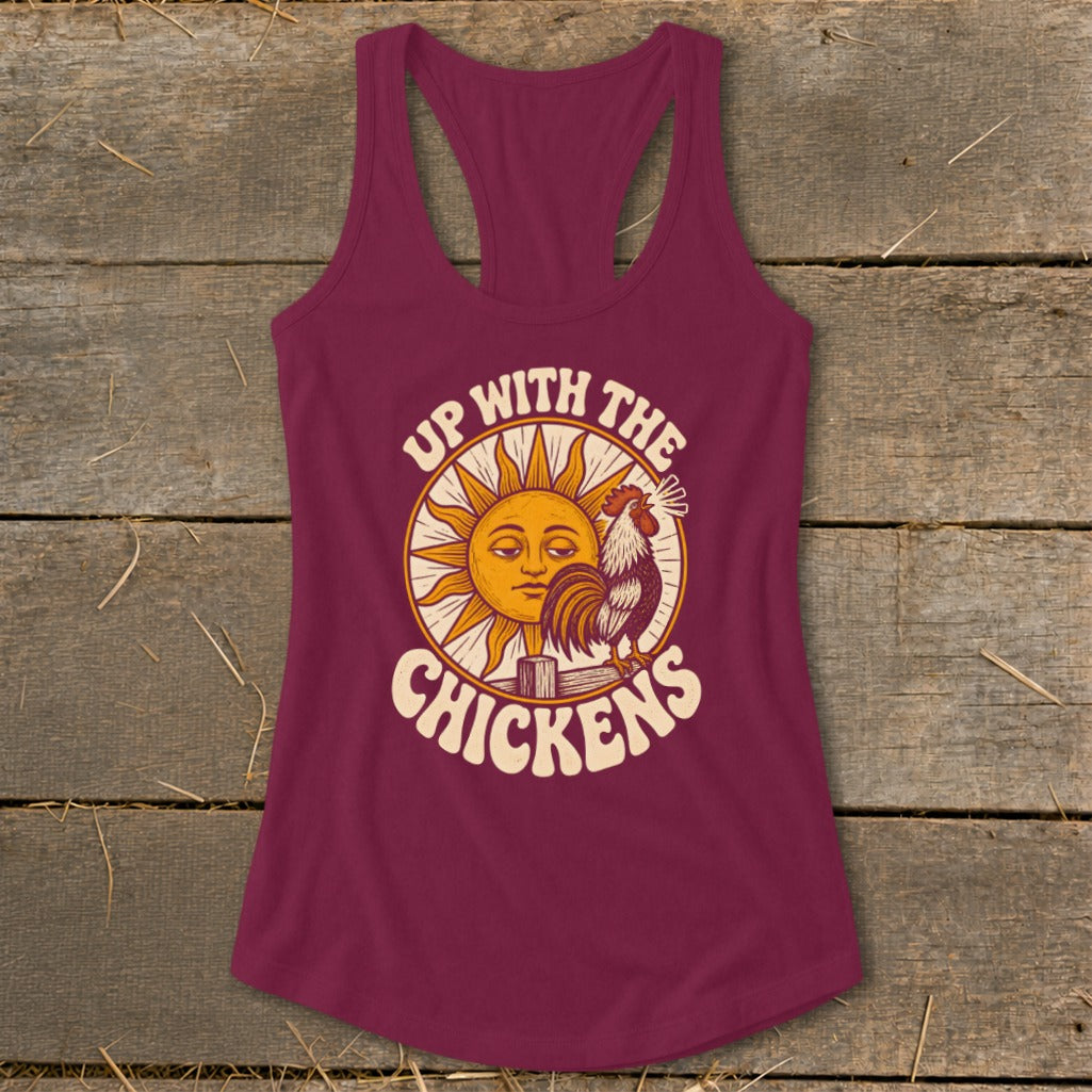 Maroon racerback tank top featuring a retro graphic with a rooster, sun, and text reading Up With The Chickens.
