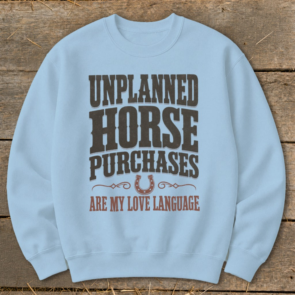 Light blue sweatshirt with "Unplanned Horse Purchases Are My Love Language" text and horseshoe.