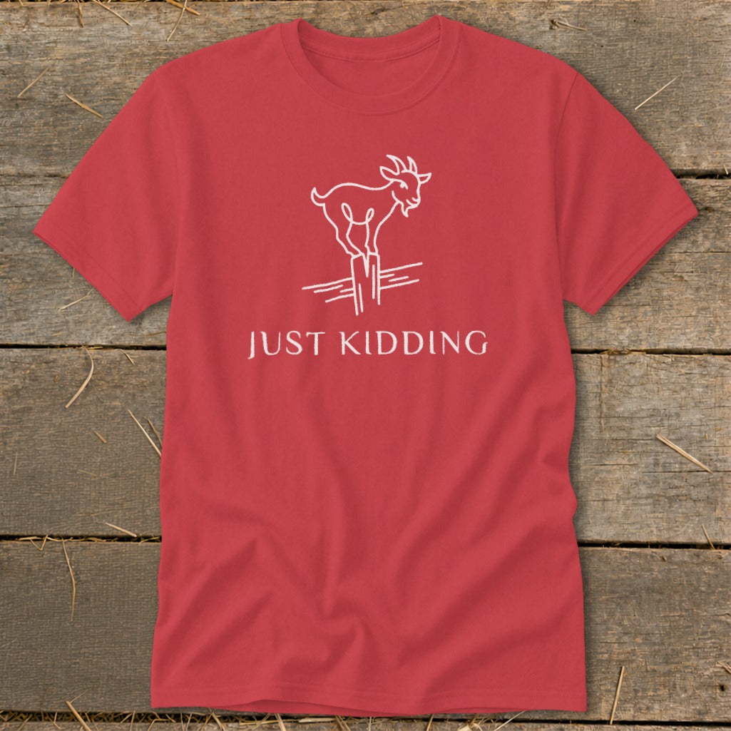 Red t-shirt with white line drawing of a goat on a fence post and text "JUST KIDDING".