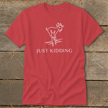 Red t-shirt with white line drawing of a goat on a fence post and text "JUST KIDDING".