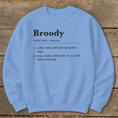 Light blue sweatshirt with "Broody" definition: hen and blanket on cold morning.