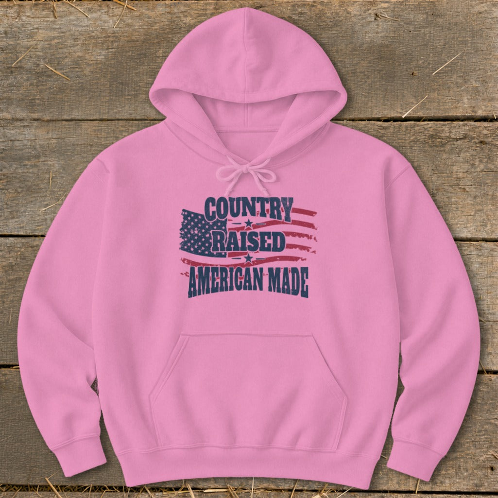 Pink hoodie with distressed American flag and text "COUNTRY RAISED AMERICAN MADE".