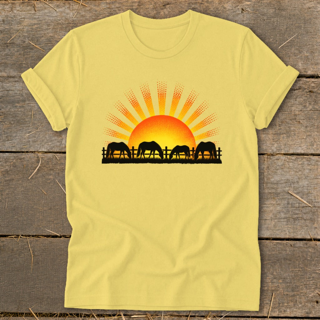 Yellow t-shirt with horses grazing at sunset graphic.