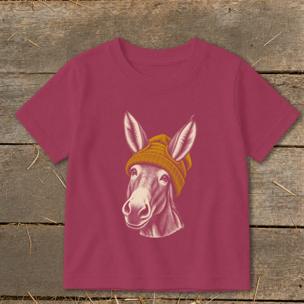 Donkey wearing a yellow beanie, graphic on a magenta t-shirt.