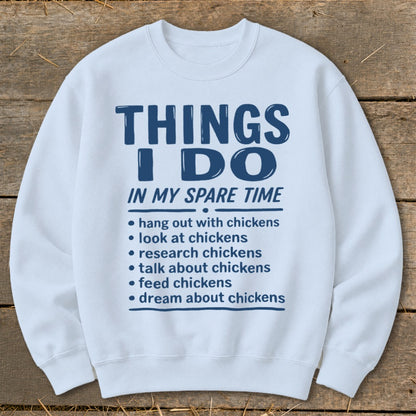 White sweatshirt with blue text "Things I Do In My Spare Time" and chicken-related activities.