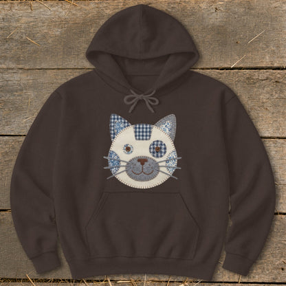 Brown hoodie with a patchwork cat face design on the chest.
