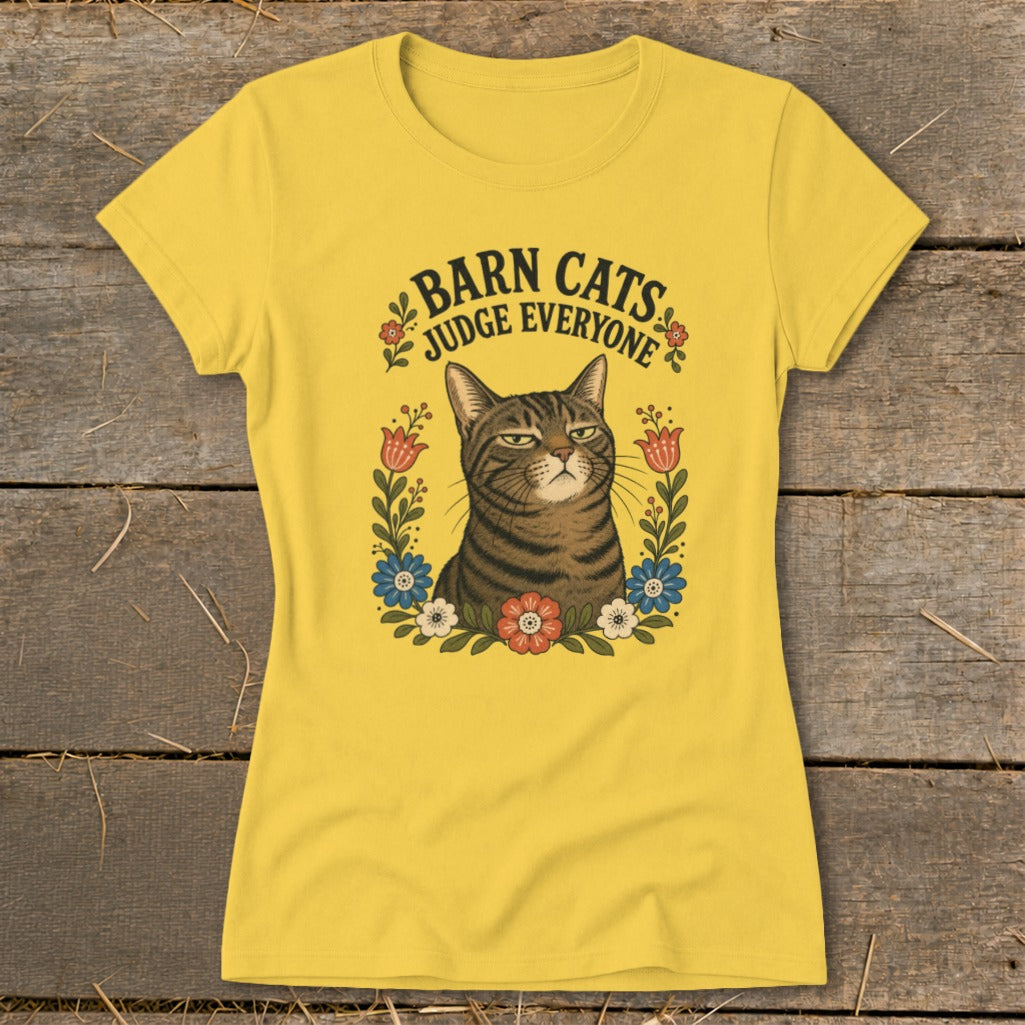 Yellow t-shirt with a tabby cat surrounded by flowers and text "Barn Cats Judge Everyone."