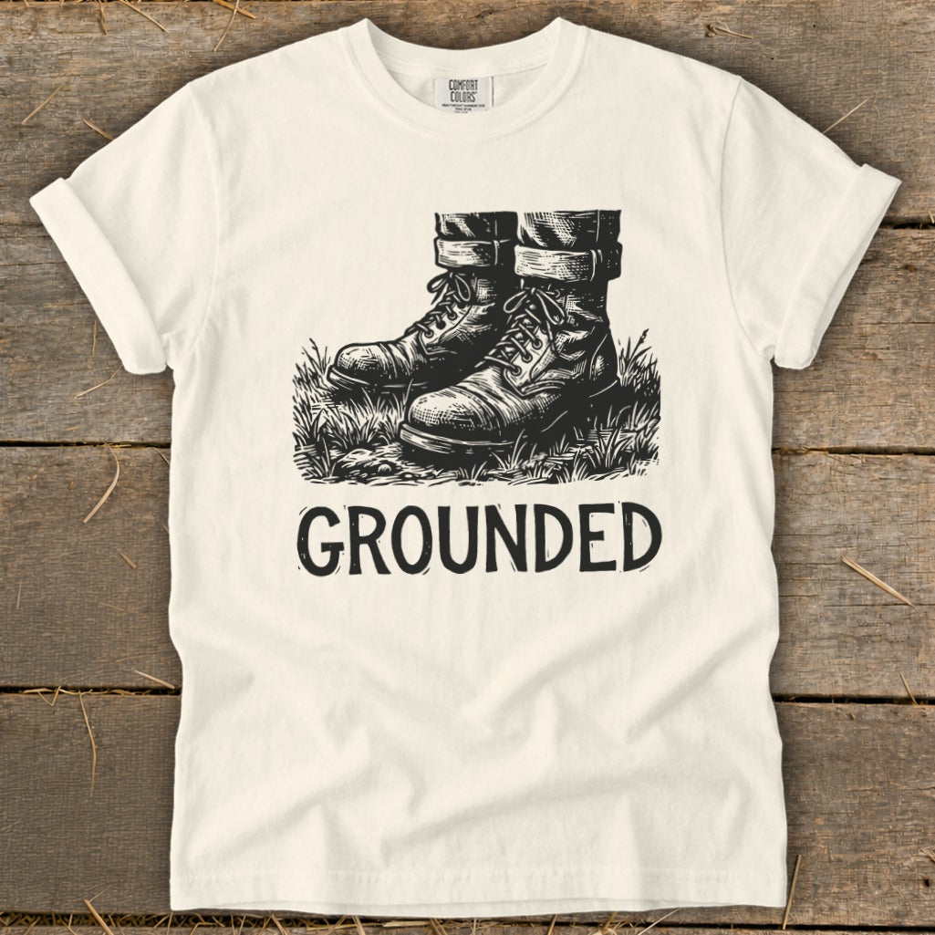 Cream t-shirt with black graphic of boots and the word "GROUNDED".
