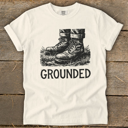 Cream t-shirt with black graphic of boots and the word "GROUNDED".