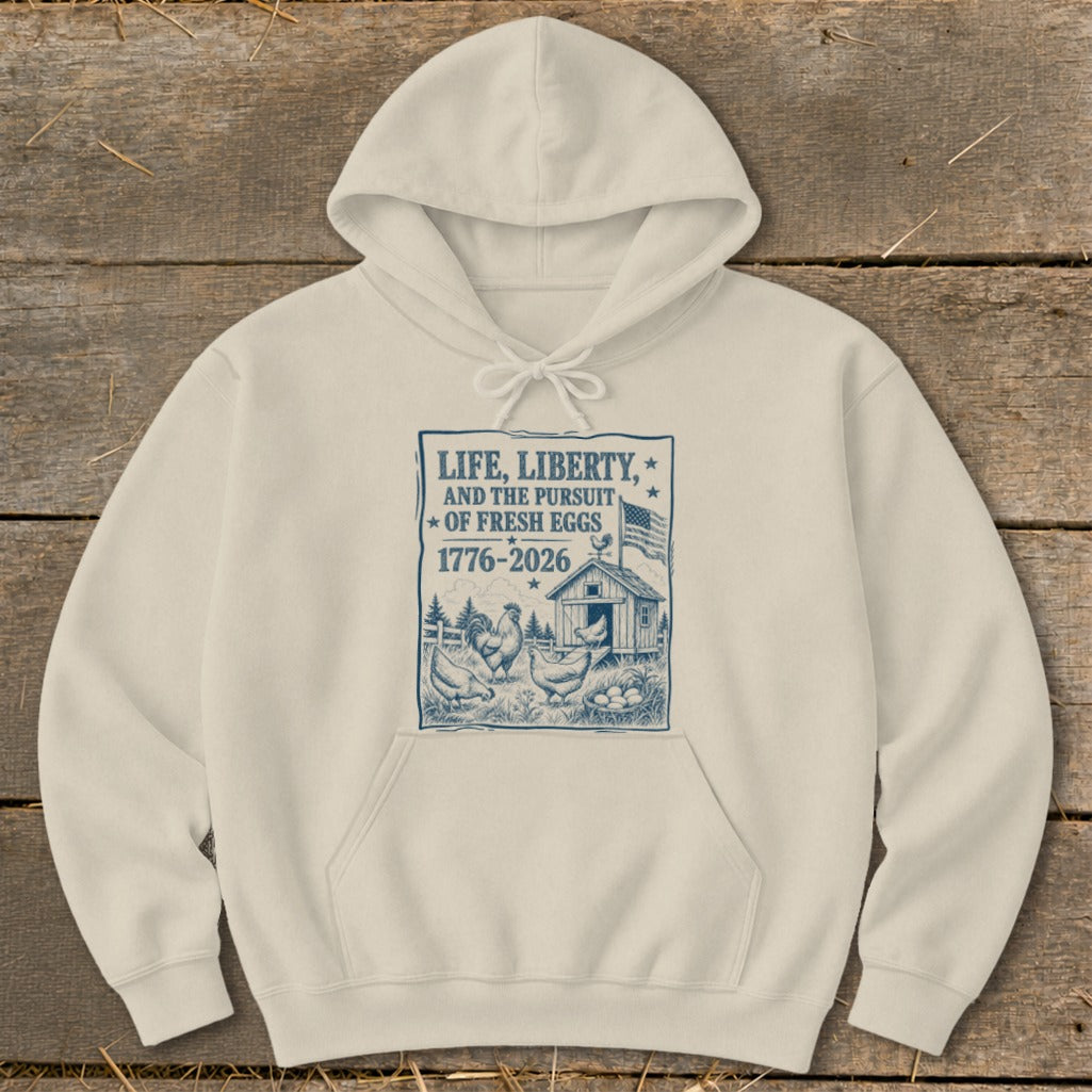 Cream hoodie with graphic: "Life, Liberty, and the Pursuit of Fresh Eggs 1776-2026".