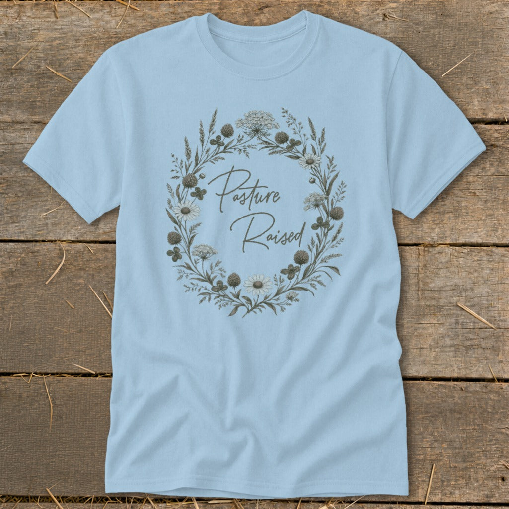 Light blue t-shirt with a floral wreath graphic that reads "Pasture Raised".