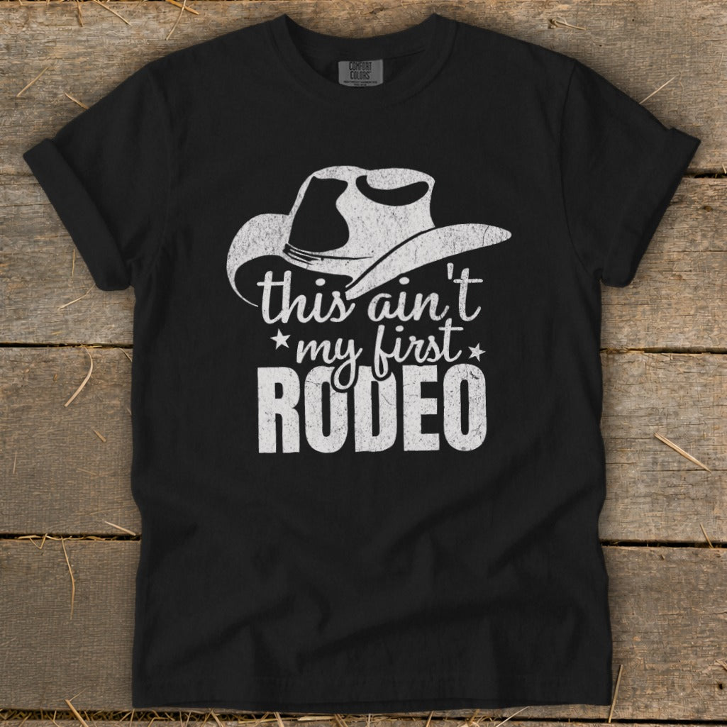 Black t-shirt with white cowboy hat graphic and text "this ain't my first RODEO".