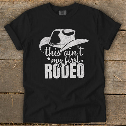 Black t-shirt with white cowboy hat graphic and text "this ain't my first RODEO".