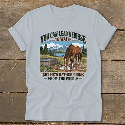 Light blue t-shirt featuring a horse drinking from a puddle with text above and below.