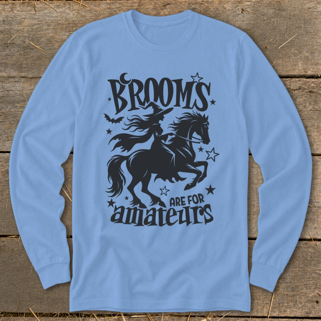 Light blue long-sleeve shirt with black graphic of witch on a horse and text "BROOMS ARE FOR AMATEURS".