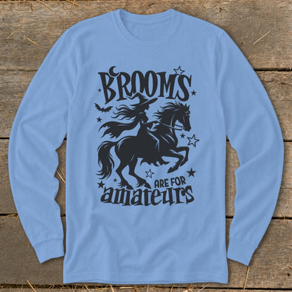 Light blue long-sleeve shirt with black graphic of witch on a horse and text "BROOMS ARE FOR AMATEURS".