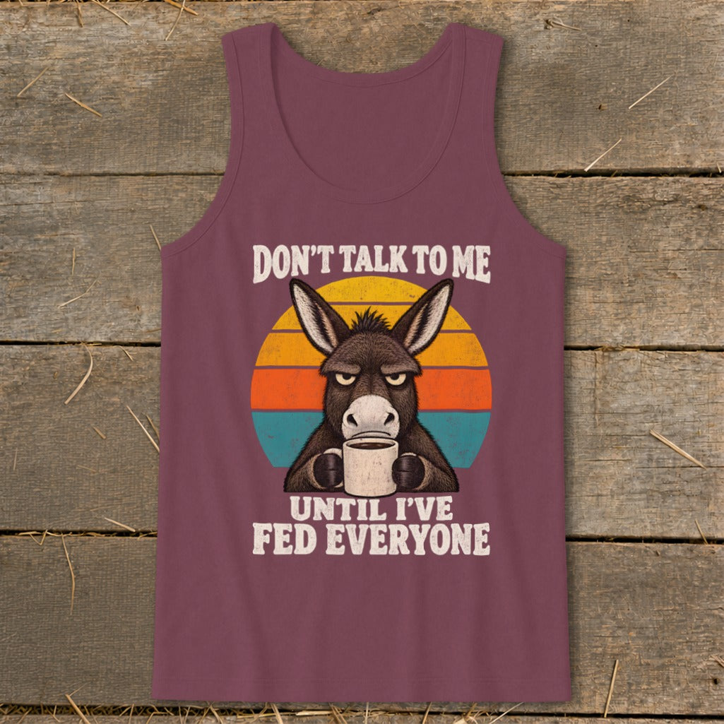 Maroon tank top featuring a grumpy donkey holding a mug with the text Don't Talk To Me Until I've Fed Everyone.