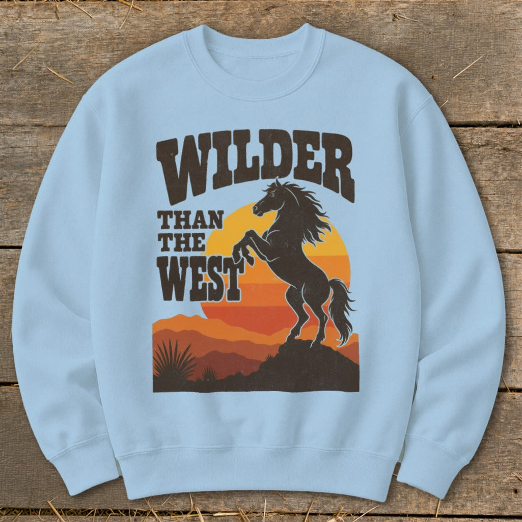 Light blue sweatshirt with "WILDER THAN THE WEST" and rearing horse graphic.