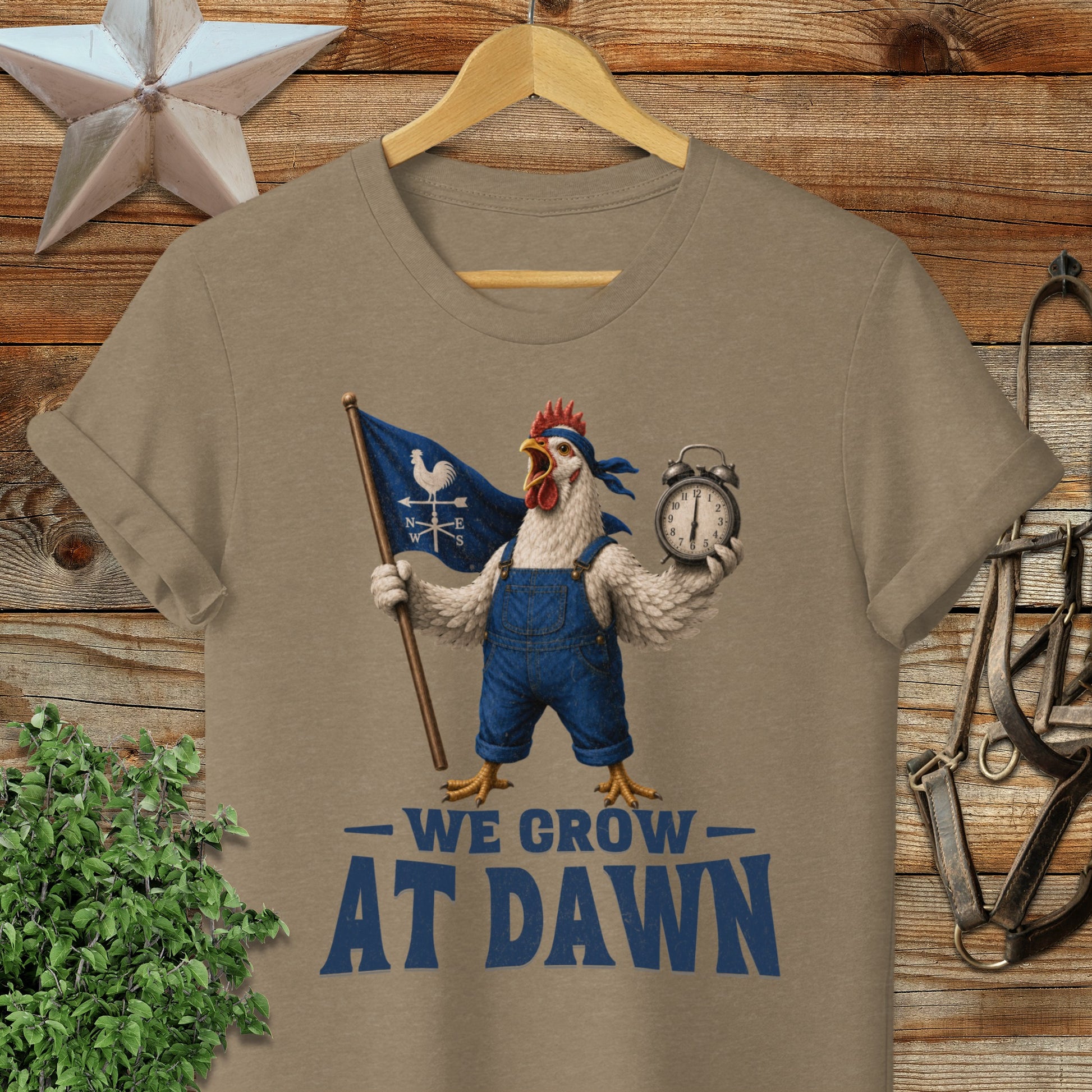 Chicken in overalls holding flag that says "WE GROW AT DAWN".