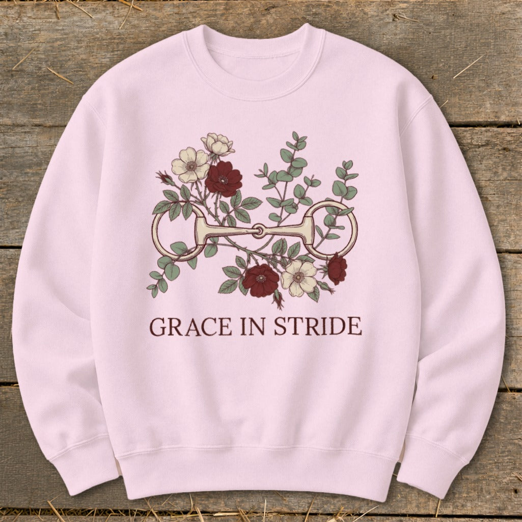 Pink sweatshirt with floral horse bit graphic and "GRACE IN STRIDE" text.