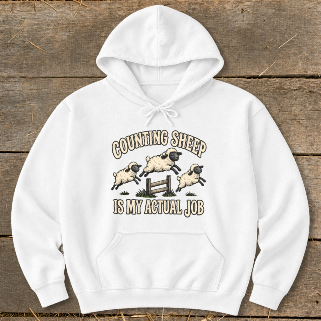 White hoodie with "COUNTING SHEEP IS MY ACTUAL JOB" text and jumping sheep graphic.