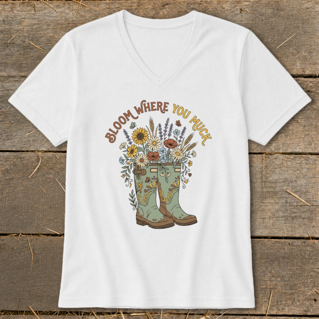 White t-shirt with "Bloom Where You Muck" text and floral garden boots graphic.