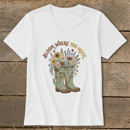 White t-shirt with "Bloom Where You Muck" text and floral garden boots graphic.