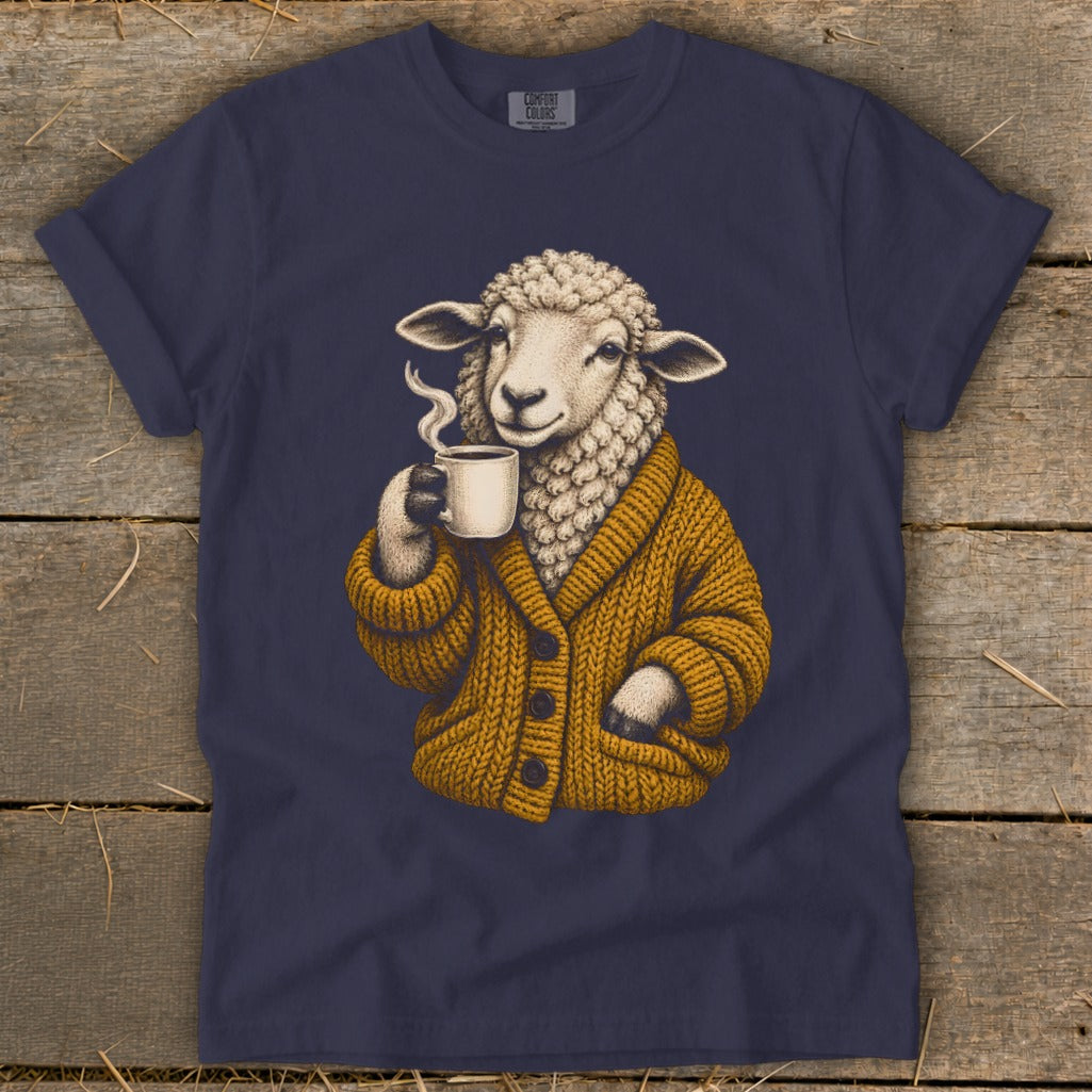 Dark blue t-shirt featuring an illustration of a sheep wearing a mustard-yellow cardigan and drinking coffee.