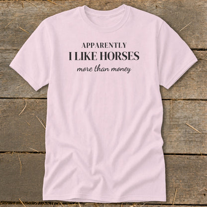 Pink t-shirt with black text "APPARENTLY I LIKE HORSES more than money".