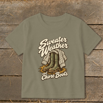 "Sweater Weather and Chore Boots" graphic on a taupe t-shirt.