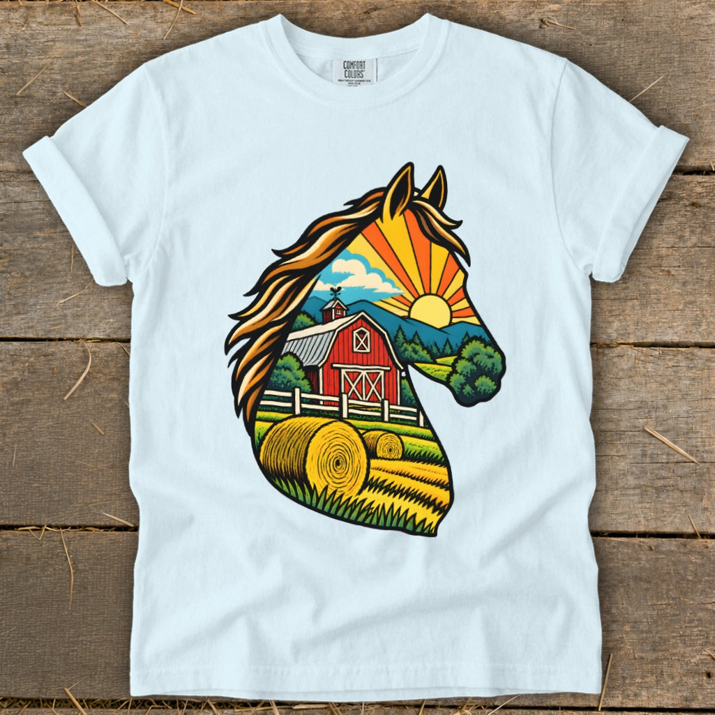 A light blue t-shirt with a colorful graphic of a horse head silhouette framing a farm landscape.