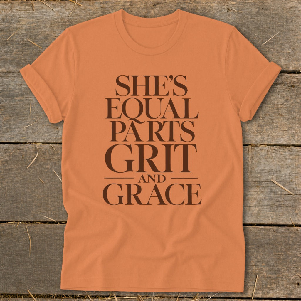 Orange t-shirt with text "She's equal parts grit and grace".