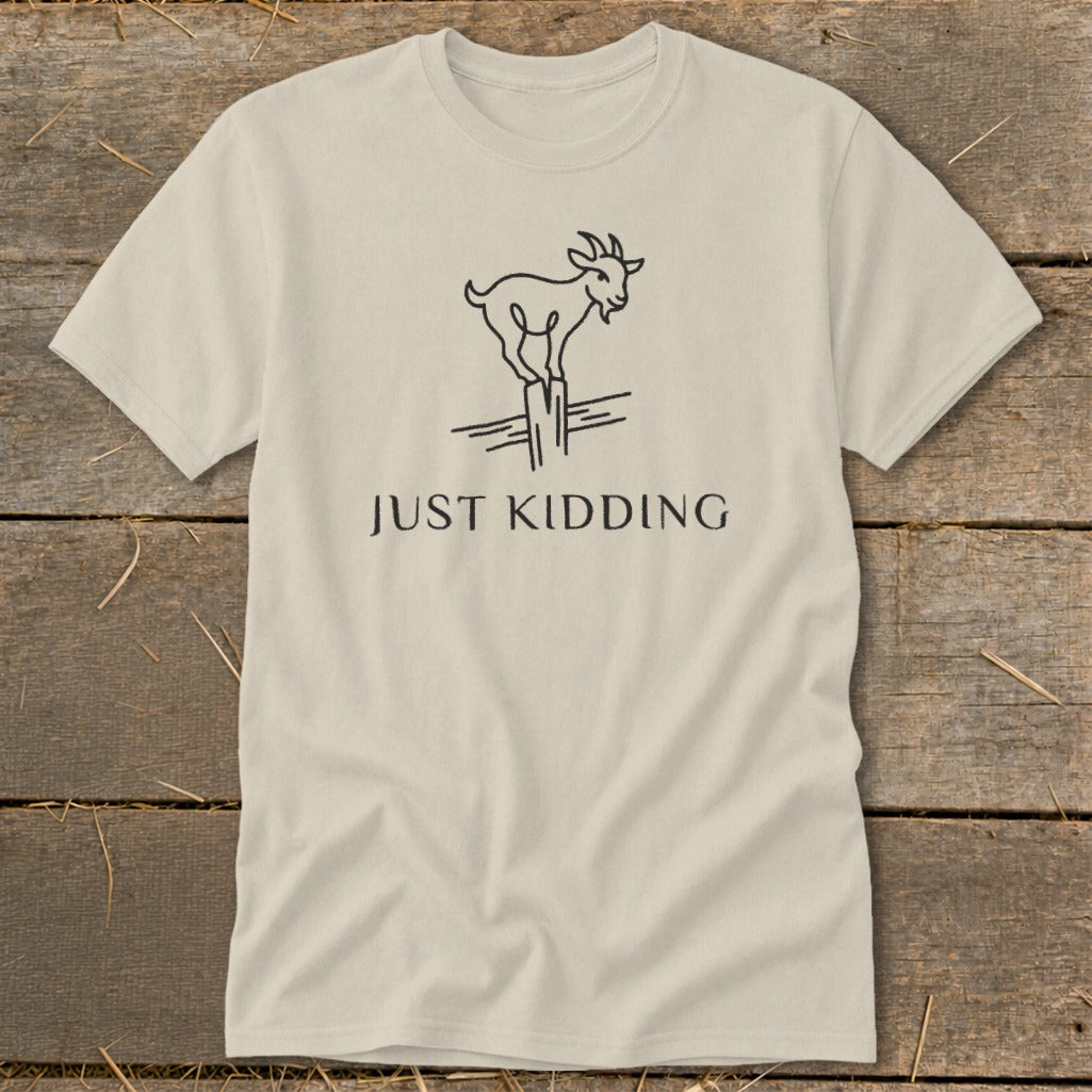 Cream t-shirt with a minimalist goat illustration and "JUST KIDDING" text.