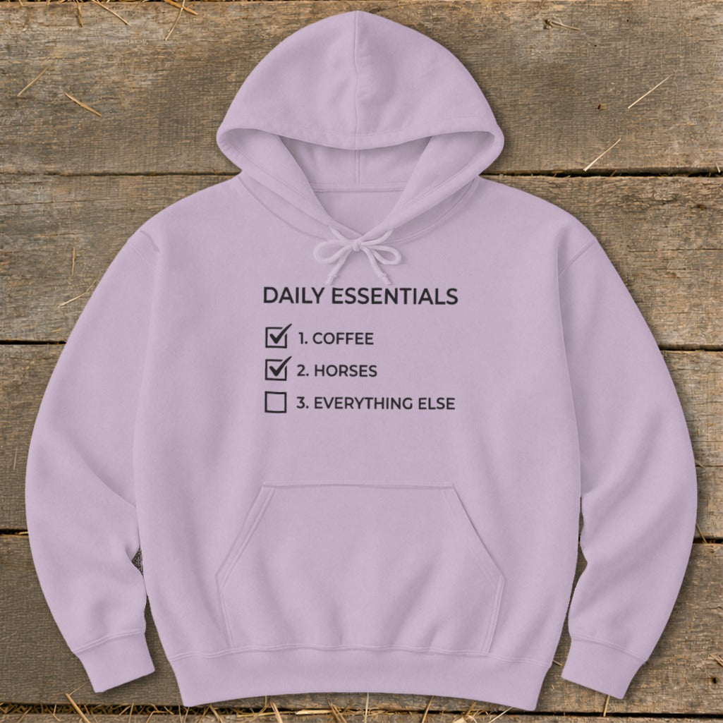 Lilac hoodie with "Daily Essentials" checklist: coffee, horses, everything else.