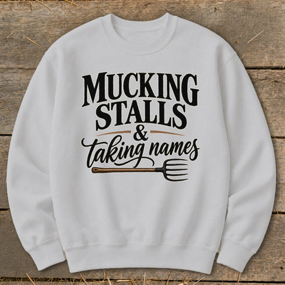 White sweatshirt with "Mucking Stalls & Taking Names" and a pitchfork graphic.
