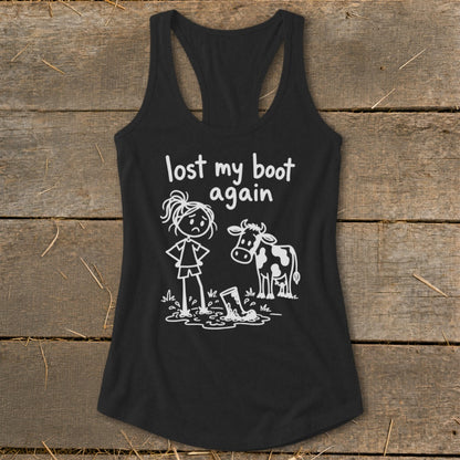 Black racerback tank top with white graphic text reading lost my boot again, featuring a stick figure and cow looking at a muddy boot.
